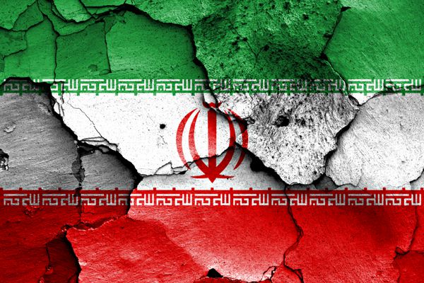پرچم ایران بر روی دیواره ترک خورده رنگ می زند