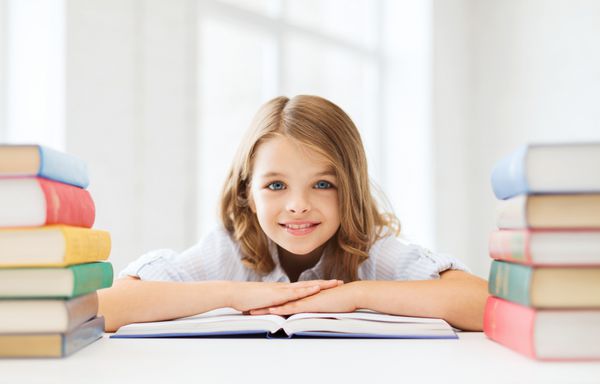 مفهوم آموزش و پرورش و مدرسه لبخند دختر دانش آموز کمی با کتاب های بسیاری در مدرسه