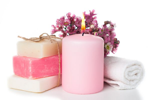 محصولات برای آبگرم حوله شمع صابون دستباف سفید و صورتی و شکوفه های گیلاس صورتی بر روی زمینه سفید جدا شده است آرایشی و بهداشتی مراقبت و بهداشت