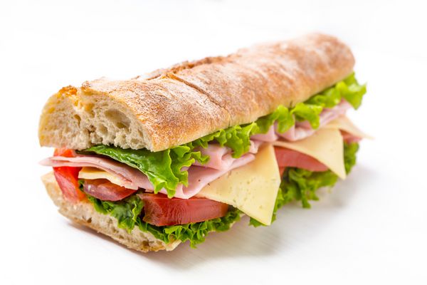 ساندویچ Ciabatta با کاهو گوجه فرنگی ژامبون و پنیر تقریبا نصف می شود