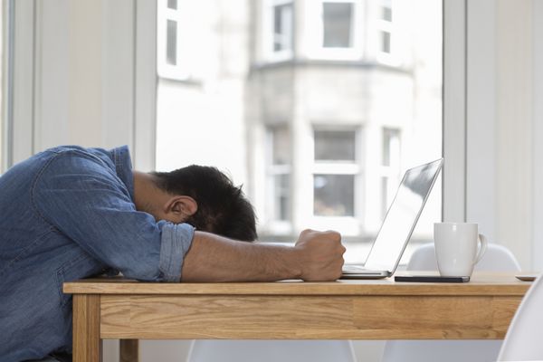 مرد آسیایی استرس زا و ناامید نشسته در لپ تاپ خود