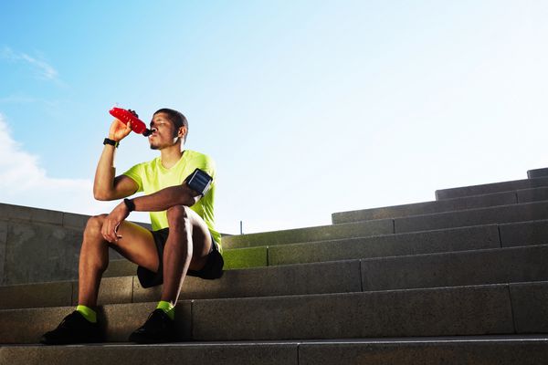 دونده فوق العاده ورزشی در مراحل نوشیدن آب مرد مناسب مناسب در ورزش های فلورسنت روشن مفهوم تناسب اندام ورزشی