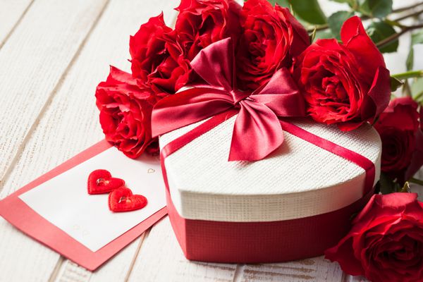 جعبه هدیه و دسته گل رز برای تعطیلات در زمینه های چوبی