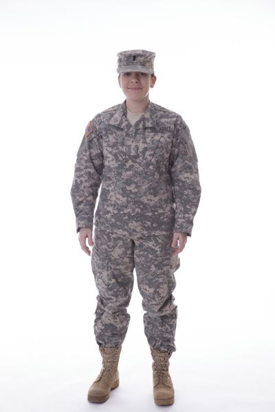 زن نظامی ایستاده و لبخند استودیو در پس زمینه سفید