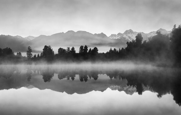 بازتاب های زیبا از کوه های جنوبی در دریاچه Matheson نیوزیلند در اوایل صبح صبح در سیاه و سفید