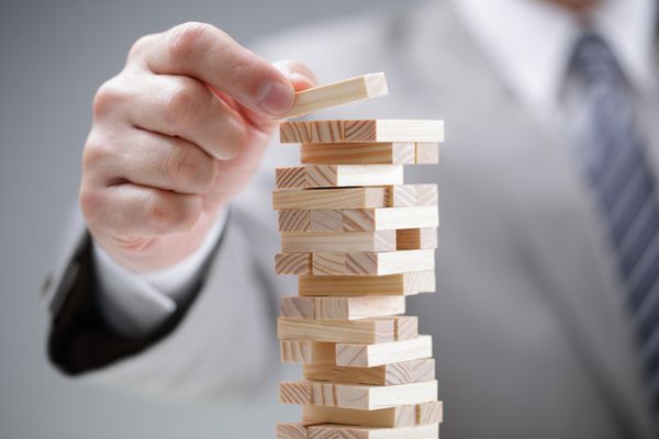 برنامه ریزی ریسک و استراتژی در کسب و کار تاجر قرار دادن بلوک چوبی در یک برج