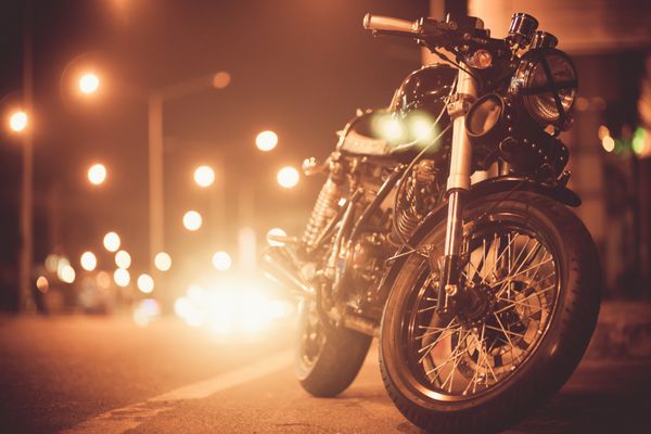 موتور سیکلت بر روی جاده در شب به سمت شهر