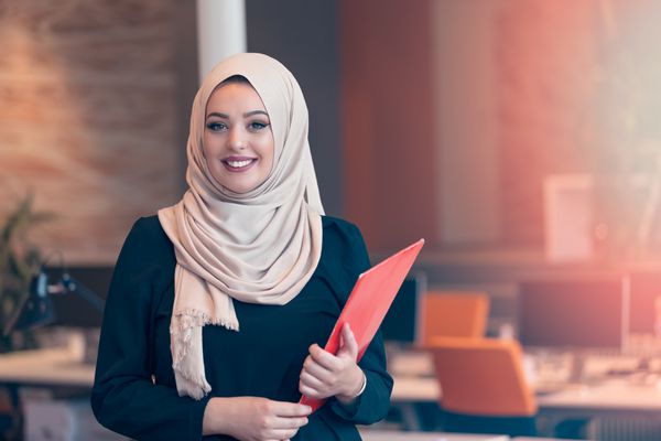 زن کسب و کار عربستان که یک پوشه را در دفتر راه اندازی مدرن نگه داشته است