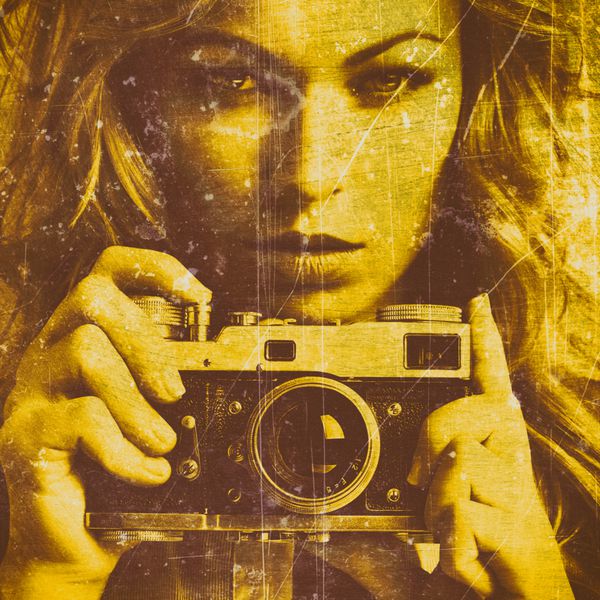 زن زیبا عکس گرفتن با دوربین فیلمبرداری یکپارچهسازی با سیستمعامل نزدیک بافت قدیمی نارنجی دیوار بتنی طلایی