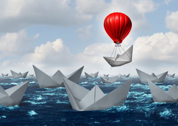 مفهوم مزیت کسب و کار و نماد تعویض بازی به عنوان یک اقیانوس با جمعیت قایق های کاغذی و یک قایق بالاتر از بقیه با بالون قرمز به عنوان یک استعاره موفقیت و نوآوری برای تفکر جدید بالا می رود
