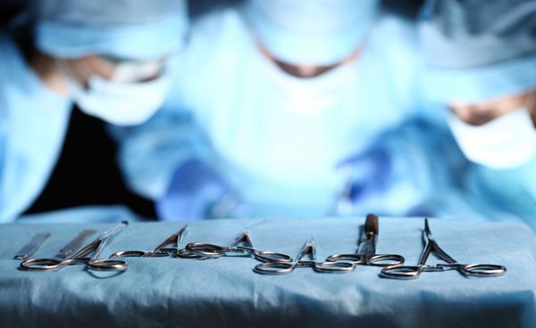 ابزار جراحی بر روی میز میز گروه جراحان در بیماران مبتلا به پس زمینه در تئاتر جراحی ابزار پزشکی فولادی آماده استفاده می شود مفهوم جراحی و اورژانس