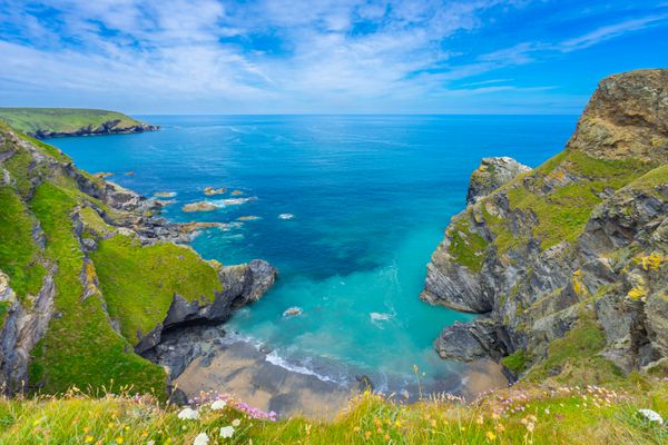 نمایش از ساحل دریای دویون انگلستان در تابستان با آب های روشن آسمان آبی و چمن