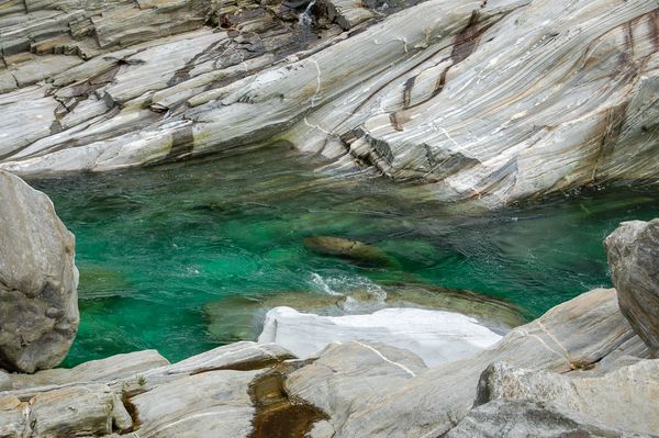 سریع آب سرد زمرد سرد بین سنگ های آب جوش در رودخانه وال Verzasca در سوئیس