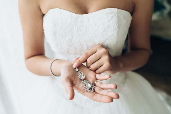 عروس زیبا با نگه داشتن نقره گوشواره مناقصه با جواهرات