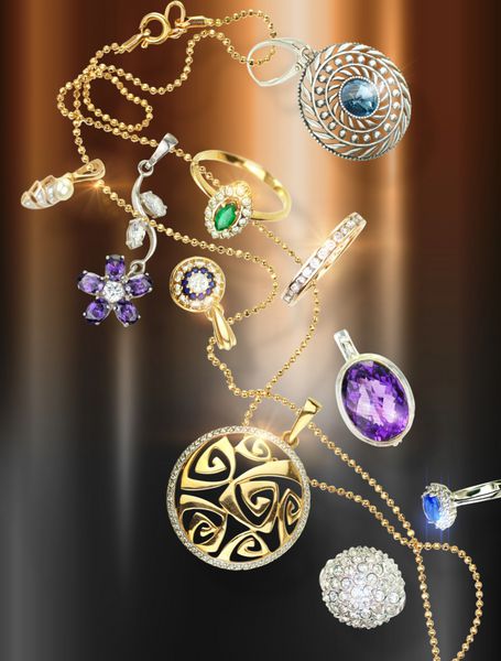 بسیاری از جواهرات زیبا با سنگ های قیمتی سقوط در پس زمینه طلایی و قهوه ای هدایای لوکس فانتزی لوکس برای جشن