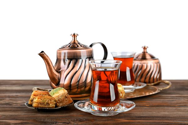 چای ترکی در شیشه های سنتی و قوری فلزی در پس زمینه سفید