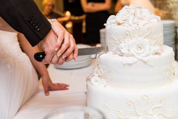عروس و داماد در پذیرش عروسی برش کیک عروسی