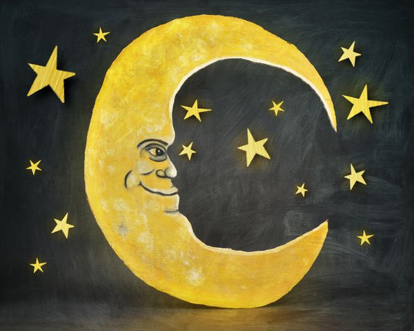 برش مقوا یک ماه زرد با ستاره در پس زمینه بر روی یک بافت تابلو برای یک خواب یا مفهوم خواب