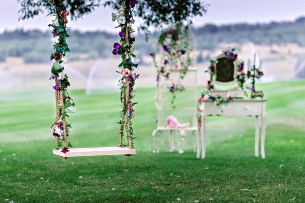 نوسان عروسی تزئین شده با گل حلق آویز در شاخه های قدیمی بید