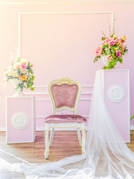 داخل اتاق کلاسیک بنفش با گلدان های گلدار روی پایه و صندلی زیبا