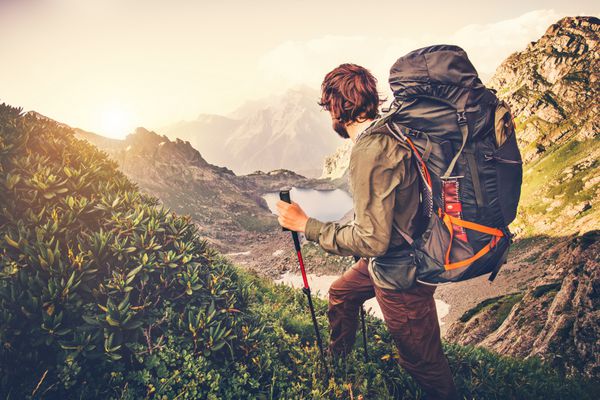 مسافر مرد با کوهنوردی کوله پشتی مفهوم سفر سبک زندگی دریاچه و کوه در پس زمینه تعطیلات تابستانی سفر در فضای باز