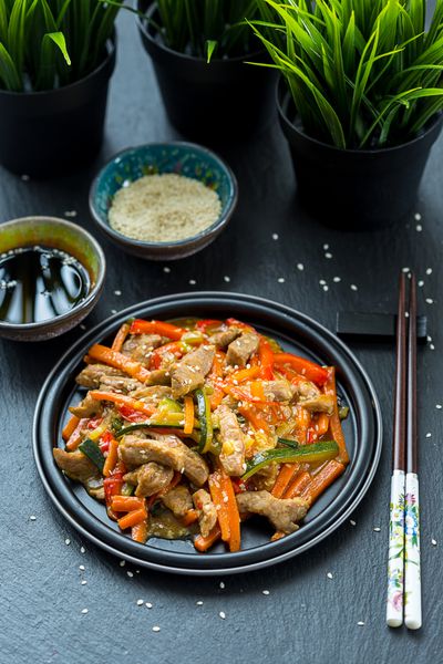 غذاهای چینی گوشت خوک با سبزیجات که عمیقا سرخ شده در سس شیرین و سس نمایش بالا عمودی