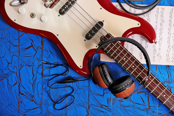 گیتار الکتریکی با هدفون و یادداشت در پس زمینه آبی رنگ