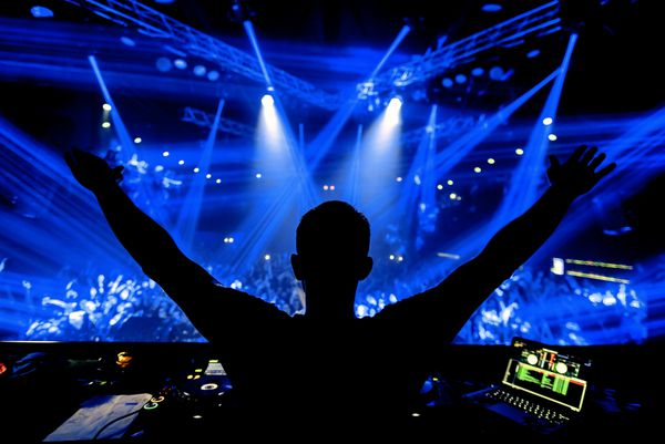 DJ در حزب باشگاه شب در زیر نور آبی با جمعیت مردم است
