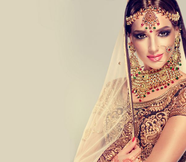 پرتره لبخند دختر زیبا هند مدل زن جوان هند با مجموعه طلایی کاندان طلایی لباس هندی سنتی هند lehenga choli