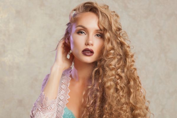 زن با مد آرایش و موهای فرفری مفهوم مراقبت از پوست و مو