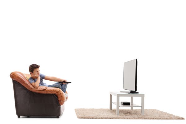 پسر کوچک خسته از تماشای تلویزیون و تغییر کانال های جدا شده بر روی زمینه سفید