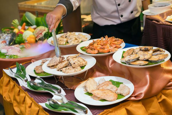 آشپز تهیه صفحات از گوشت گاو گوشت خوک گوشت گاو مرغ ماهی میگو و ماهی مرکب برای شام در یک رستوران لوکس