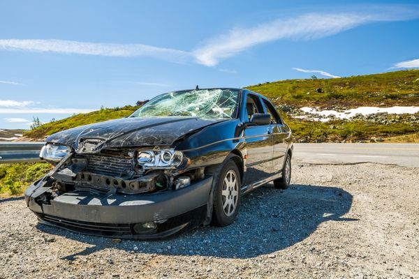 بزرگراه 7 نروژ اروپا 2014 ژوئن 15 یک ماشین به شدت آسیب دیده در یک خم شدن جاده پس از یک حادثه روز قبل پارک شده است