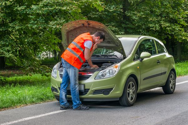 راننده جوان در تلاش برای تعمیر یک ماشین به دنبال داخل کلاه باز است