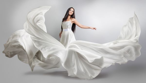 دختر جوان زیبا در پرواز لباس سفید پارچه پرتقال پارچه سفید سفید پرواز در باد