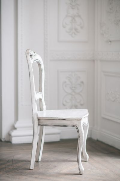 میز صندلی چوبی سفید ایستاده در مقابل یک دیوار سفید در کف پارکت سبک