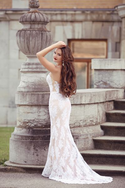 پرتره عروسی عروس زن زیبا سبک عکس رمانتیک مدل مد مدل لباس پری دریایی سفید با مجسمه گلدان موی موی بلند