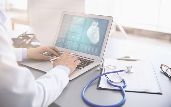 متخصص قلب با لپ تاپ در دفتر کار می کند مفهوم مراقبت از سلامت