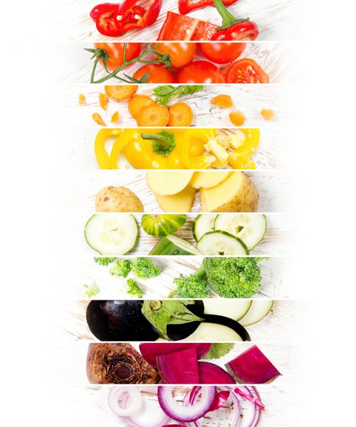 نمایش بالا از نوار های مخلوط رنگارنگ با سبزیجات بریده بر روی میز چوبی سفید؛ مفهوم تغذیه سالم؛ رنگین کمان؛ فضای سفید برای متن