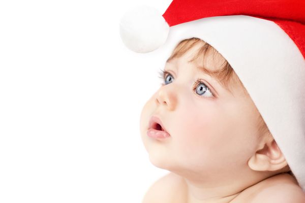 تصویر انتصاب یک پسر بچه ناز زیبا با پوشیدن کلاه قرمز بابا نوئل جدا شده بر روی زمینه سفید کریسمس سنتی