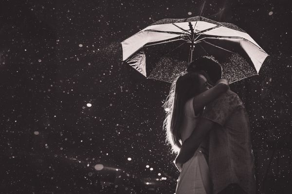 عشق در باران Silhouette بوسیدن زن و شوهر تحت چتر