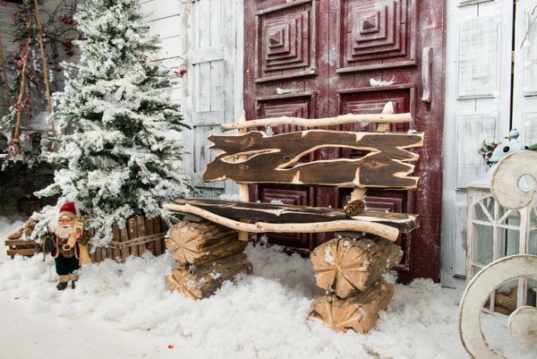 داخلی زمستان یک خانه کشور با دکوراسیون کریسمس در سبک روستایی درخت برفی و نیمکت چوبی