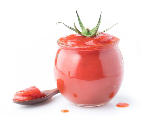 سس گوجه فرنگی کچاپ در شیشه شیشه ای در یک زمینه سفید