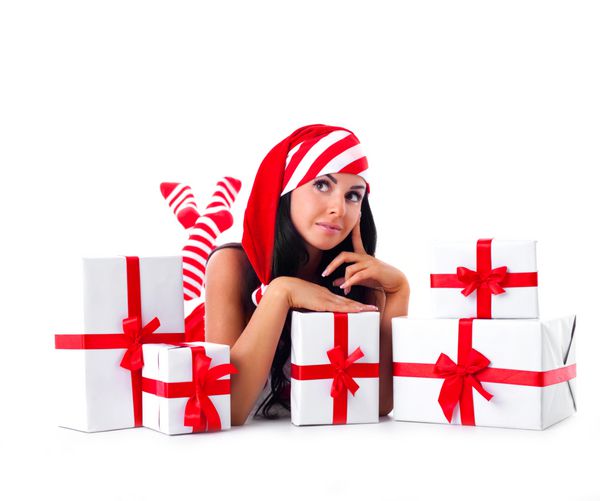 زن جوان زیبا لباس پوشیدن به عنوان سانتا نشستن بر روی زمین با بسیاری از هدایا