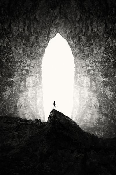ورودی غار بزرگ با چشمان انسان در صخره چشم انداز زیرزمینی سورئال