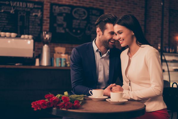 زن و شوهر عاشقانه مبارک نشسته در یک کافه نوشیدن قهوه