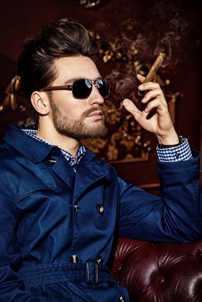 Portrait of an imposing man in sunglasses smoking a cigar Men