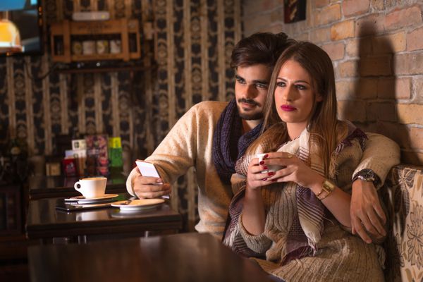 زن و شوهر زیبا در کافه نوشیدن قهوه