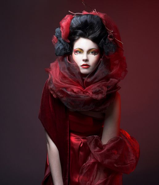 زن جوان با چهره خلاقانه در لباس قرمز و شال