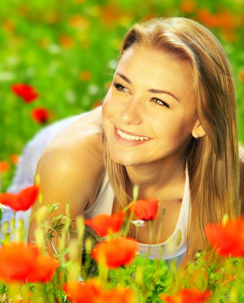 دختر جوان زیبا با بهره گیری از زمینه گل خشخاش پرتره در فضای باز مفهوم سرگرمی تابستان